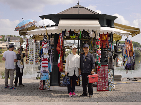 Chinesisches Paar vor Souvenir Stand