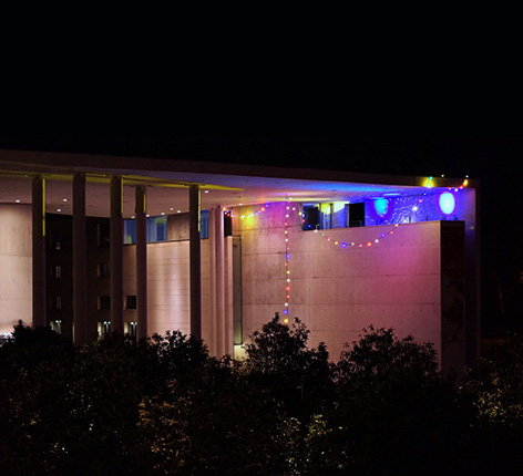 Lichterketten und Discobeleuchtung an Betonwand moderner Architektur